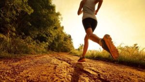 exercícios aeróbicos para emagrecer - mulher correndo em uma estrada de chão